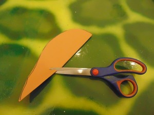 For a mouse’s body, fold a piece of thick paper in half. Draw a curve against the fold and a short line down from the fold. Cut the body out, keeping the paper folded and cut along the short line